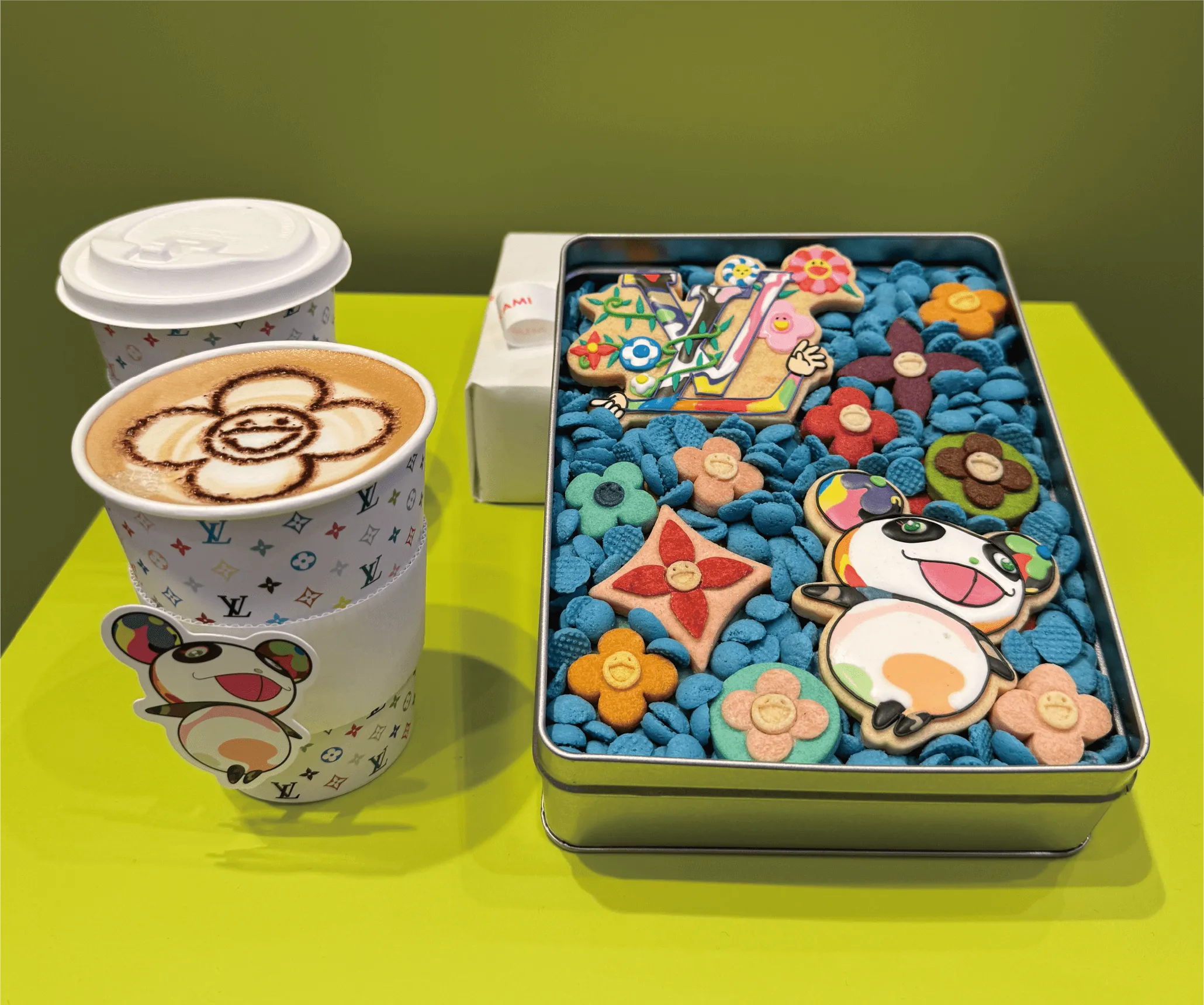 カフェラテの上に描かれたキャラクターLVロゴの紙コップ